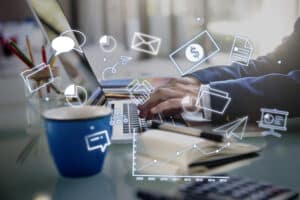 ilustração do ideal de négocio e marketing, com um notebook e um homem empresário digitando com imagens que remetem á junção de internet e empresário, aos redores.